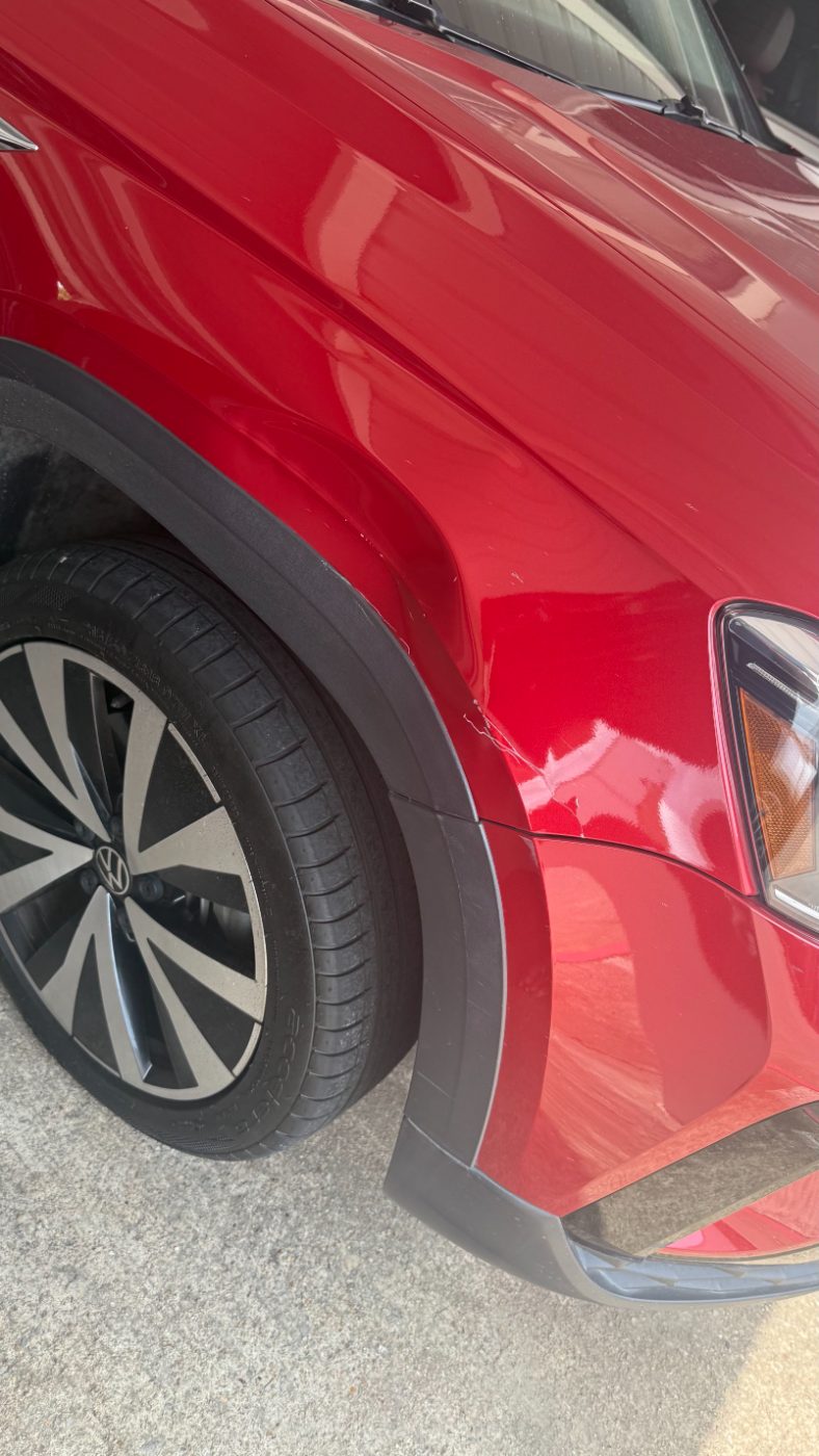 Volkswagen Taos front fender with a crease at the wheel arch before repair